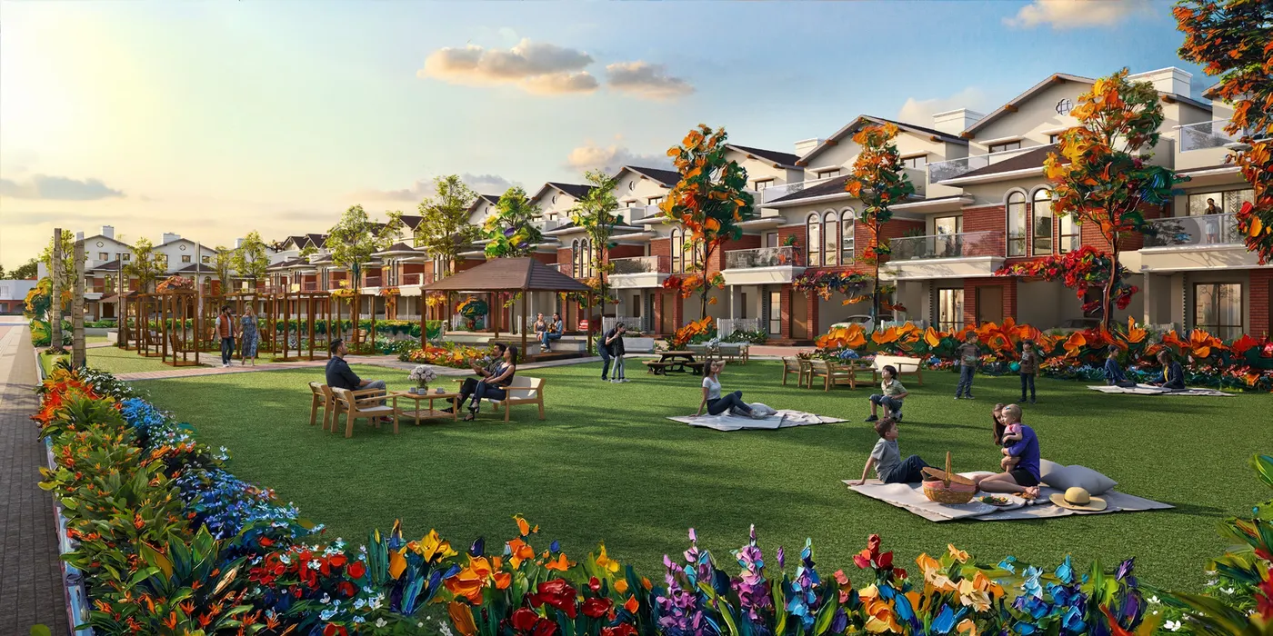 Families relaxing on the party lawn between red-brick villas at NVT Villas, Varthur